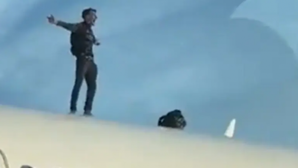 رجل يصعد على سطح طائرة ويؤخر الرحلة ساعتين